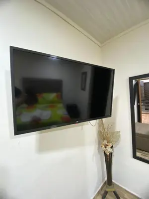 a flat screen tv hanging on a wall at Oak Tree house in Guatapé