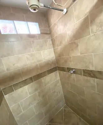 a bathroom with a shower with tan tile at Oak Tree house in Guatapé