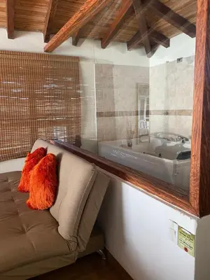 a bath room with a couch and a tub at Oak Tree house in Guatapé