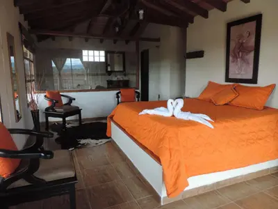 a bedroom with an orange bed with towels on it at Oak Tree house in Guatapé