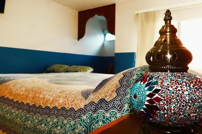 a bedroom with a bed with a colorful bedspread at Hotel Portobelo Guatape in Guatapé