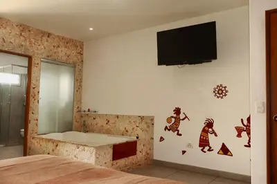 a bedroom with a bed and a tv on the wall at Hotel Portobelo Guatape in Guatapé