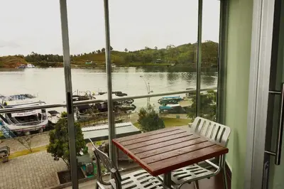 a balcony with a table and a view of a marina at Hotel Portobelo Guatape in Guatapé