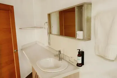 a bathroom with a sink and a mirror at Hotel Portobelo Guatape in Guatapé