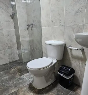 a bathroom with a toilet and a shower and a sink at hotel medellin calasanz in Medellín