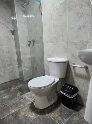 a bathroom with a toilet and a shower and a sink at hotel medellin calasanz in Medellín