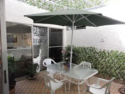 a table and chairs with an umbrella on a patio at hotel medellin calasanz in Medellín