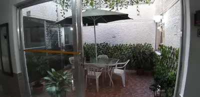 a patio with a table and an umbrella at hotel medellin calasanz in Medellín