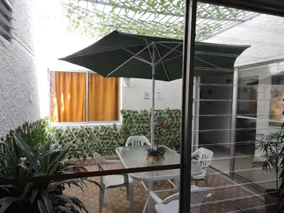 a table and chairs with an umbrella on a patio at hotel medellin calasanz in Medellín