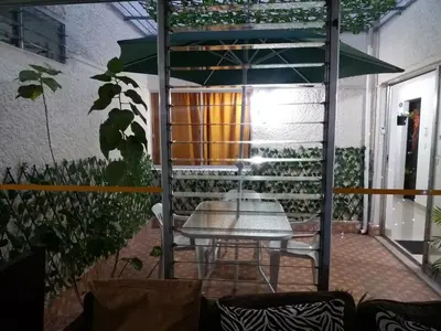 a patio with a table and some plants at hotel medellin calasanz in Medellín