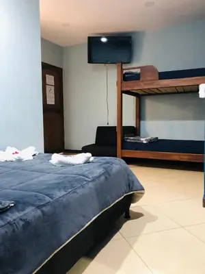 a bedroom with a bunk bed and a television at Lake View Hostel in Guatapé
