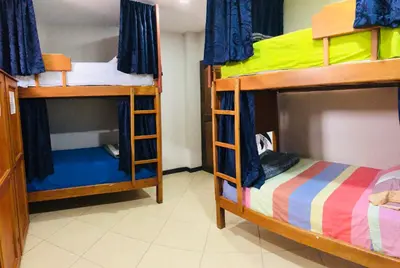 a room with two bunk beds and a small bed at Lake View Hostel in Guatapé