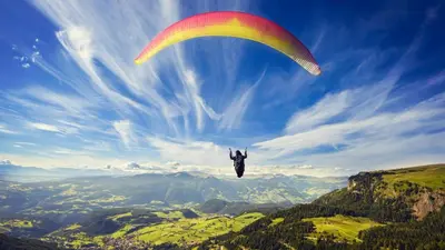 a person flying a parachute in the sky at Lake View Hostel in Guatapé