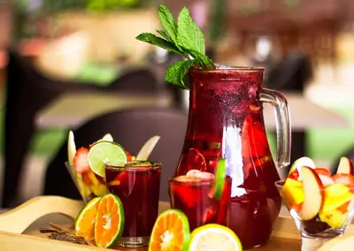 a pitcher of iced tea with fruit on a table at Hotel Lomas 10 Medellin in Medellín