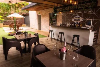 a restaurant with tables and chairs and a bar at Hotel Lomas 10 Medellin in Medellín