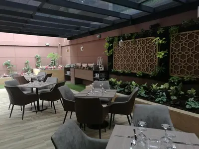 a restaurant with tables and chairs and plants at Hotel Lomas 10 Medellin in Medellín