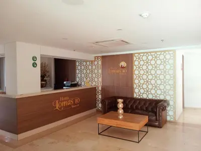 a lobby with a leather couch and a table at Hotel Lomas 10 Medellin in Medellín