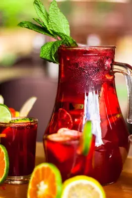 a red pitcher of iced tea with oranges and lime at Hotel Lomas 10 Medellin in Medellín