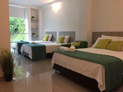 a bedroom with two beds and a large window at Biohotel Rio Claro in Doradal