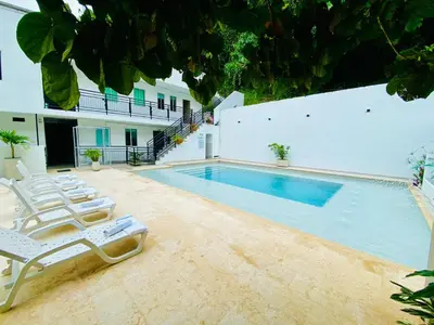 a swimming pool with lounge chairs next to a building at Biohotel Rio Claro in Doradal