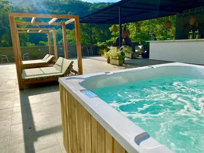 a jacuzzi tub on a patio with a pergola at Biohotel Rio Claro in Doradal