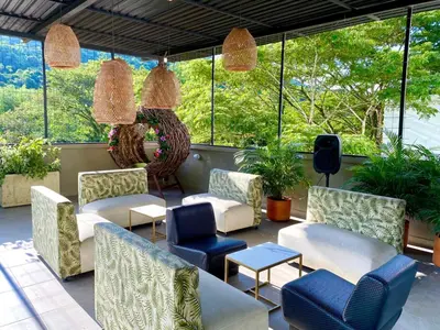 a patio with chairs and tables and windows at Biohotel Rio Claro in Doradal