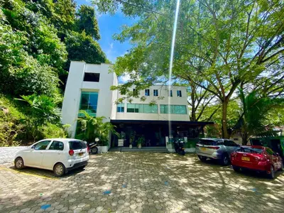 a white building with cars parked in front of it at Biohotel Rio Claro in Doradal