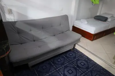 a couch and a bed in a small room at Apartahotel El Horizonte in Guatapé