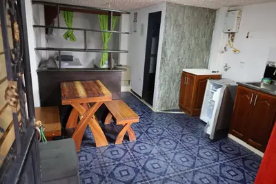 a kitchen with a table and a stool in a room at Apartahotel El Horizonte in Guatapé