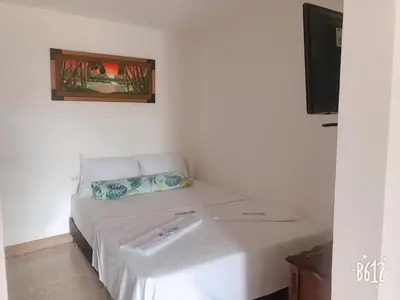 a bed in a room with a picture on the wall at Apartahotel El Horizonte in Guatapé
