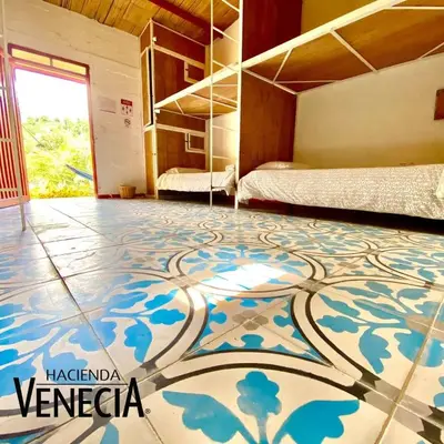 a room with two beds and a tiled floor at Hacienda Venecia Hostel in Manizales