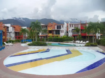 a large swimming pool with palm trees and buildings at Apartasol San Jeronimo in San Jerónimo
