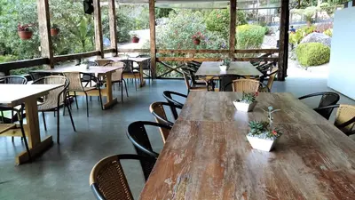 an empty restaurant with wooden tables and chairs at Hotel Termales Tierra Viva in Manizales
