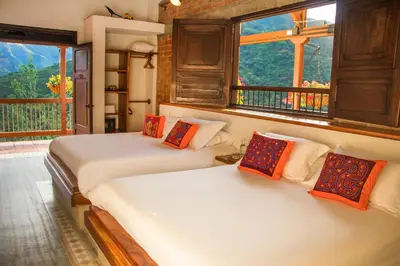 two beds in a room with two windows at Finca Boutique el Diamante in Salgar