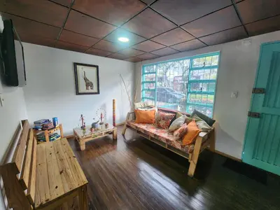 a living room with a couch and a window at Hostal Triangulo del Café in Manizales