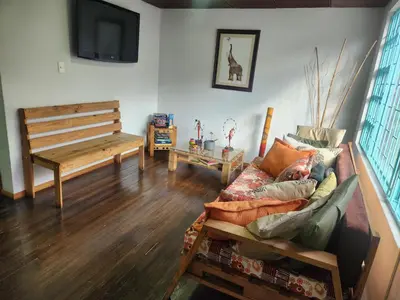 a living room with a couch and a bench at Hostal Triangulo del Café in Manizales