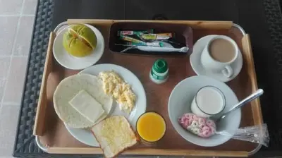 a tray with breakfast foods and a cup of coffee at Hotel Med Estadio in Medellín