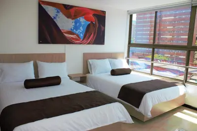 a hotel room with two beds and a window at Hotel Med Estadio in Medellín