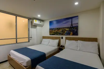 a bedroom with two beds and a picture of the eiffel tower at Hotel Med Estadio in Medellín