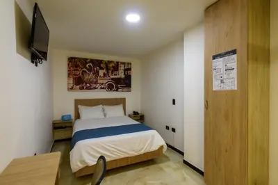 a bedroom with a bed and a television in it at Hotel Med Estadio in Medellín