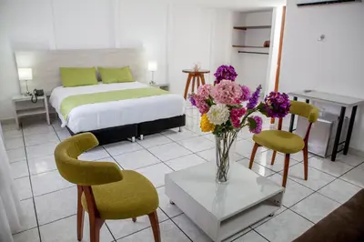 a bedroom with a bed and a vase of flowers on a table at Hotel Florida Inn in Medellín