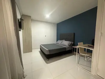 a bedroom with a bed and a table and a desk at Hotel Florida Inn in Medellín