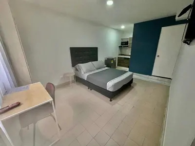 a bedroom with a bed and a kitchen in it at Hotel Florida Inn in Medellín