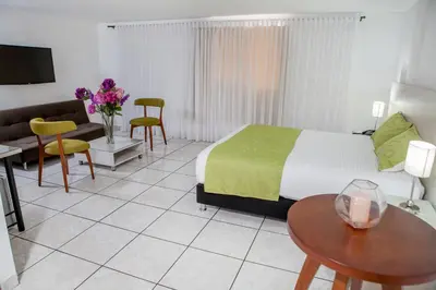 a hotel room with a bed and a table and chairs at Hotel Florida Inn in Medellín