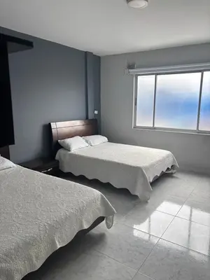 a bedroom with two beds and a window at Hotel Madeira in Manizales