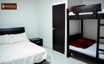 a bedroom with two bunk beds and a bed at Hotel Madeira in Manizales