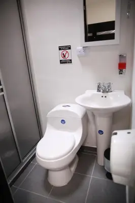 a bathroom with a toilet and a sink at Hotel Madeira in Manizales