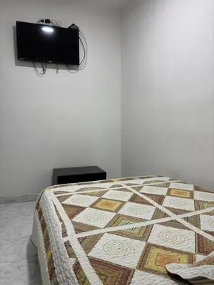 a bedroom with a bed with a tv on the wall at Hotel Madeira in Manizales