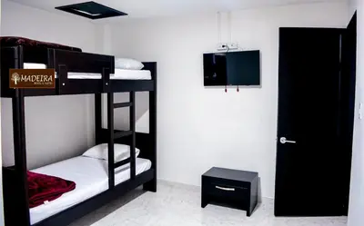 a room with two bunk beds and a door at Hotel Madeira in Manizales
