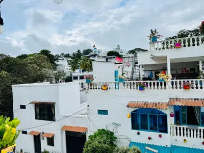 a white building with balconies on top of it at Cabaña La Aldea - Santorini Colombiano in Doradal